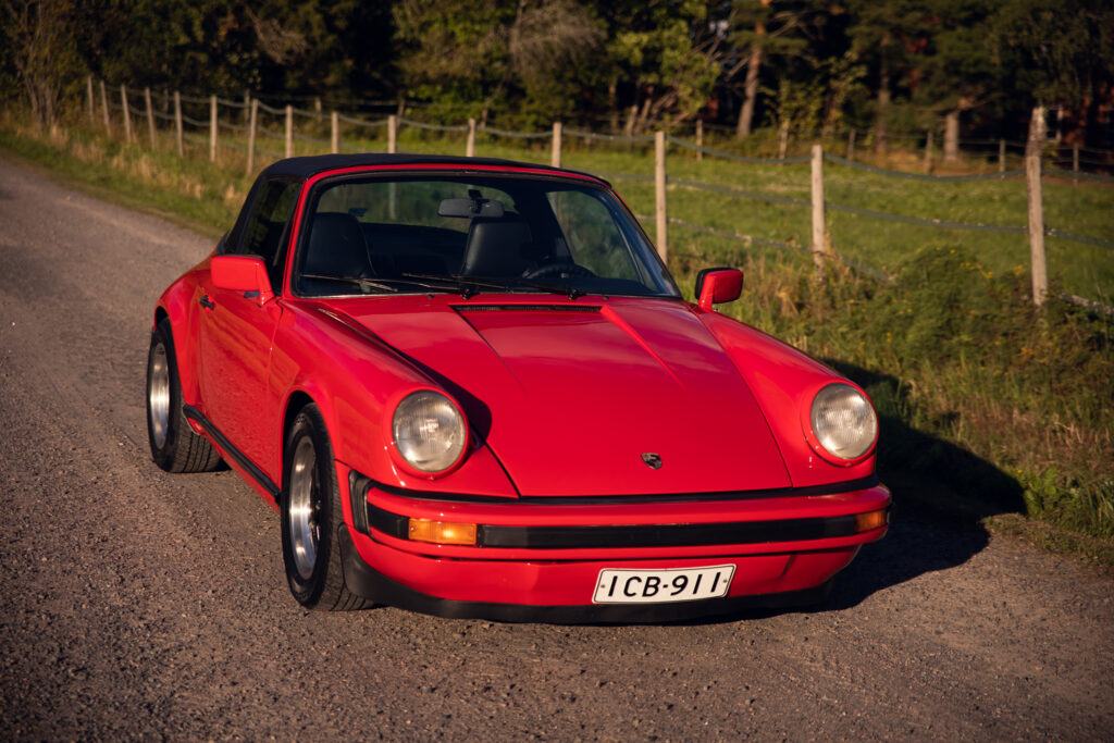Vintage red Porsche on rural road at sunset