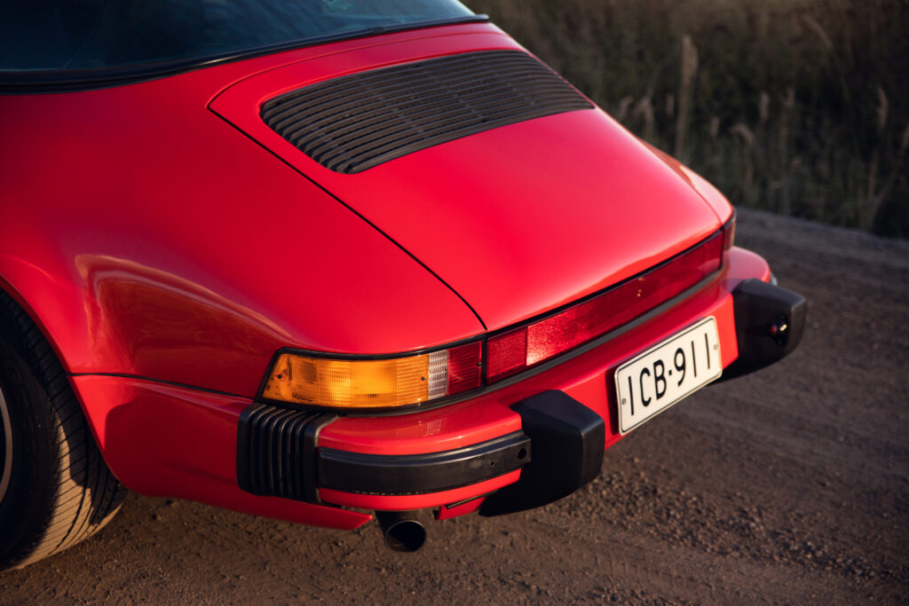 Red vintage sports car rear view at sunset