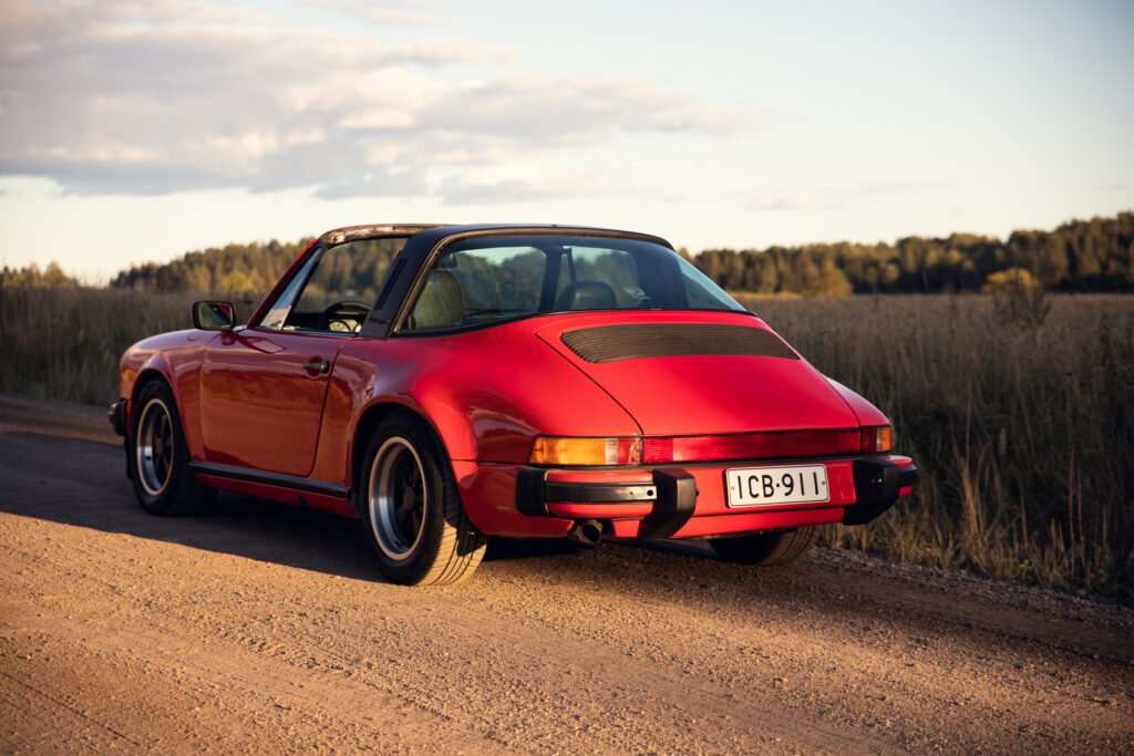 Vintage red Porsche on countryside road at sunset