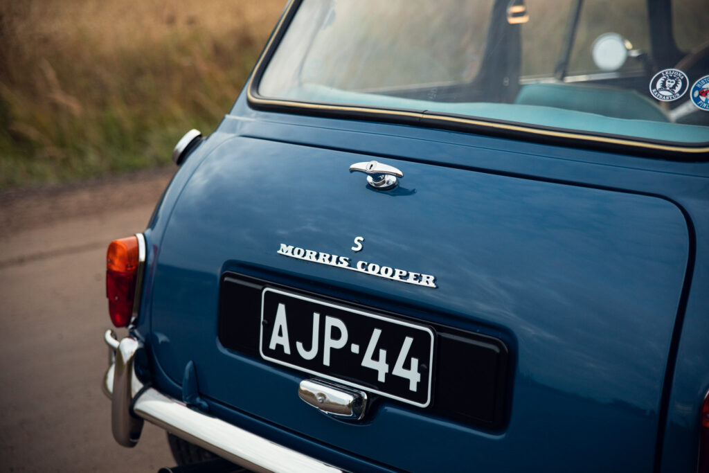 Rear view of blue Morris Cooper car on road