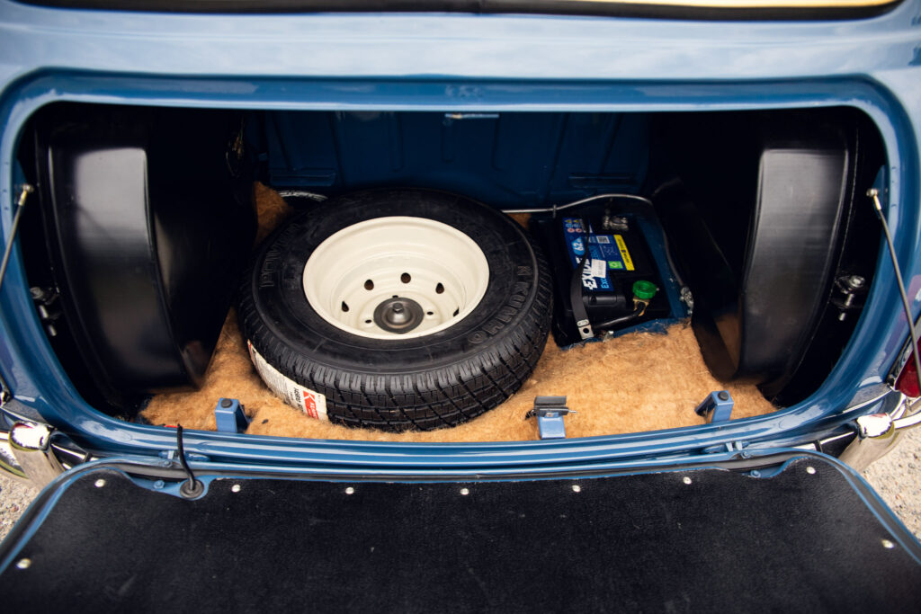 Car trunk showing spare tire and battery