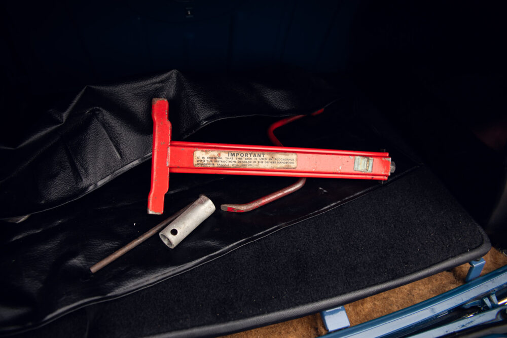 Red car scissor jack and wrench in trunk