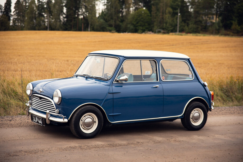 Vintage blue Mini Cooper in rural field setting