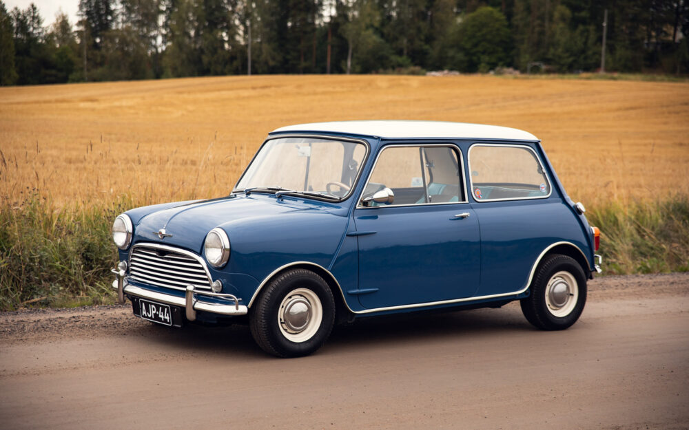 Vintage blue Mini Cooper in rural landscape