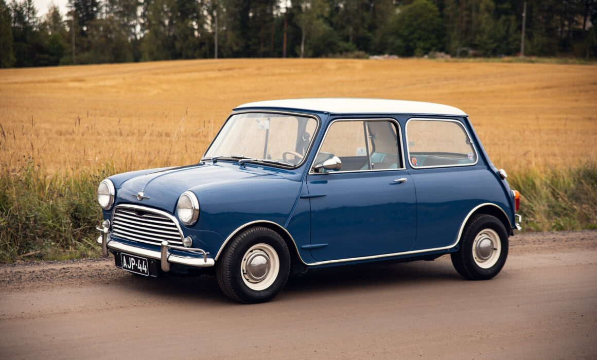 Vintage blue Mini Cooper in rural landscape