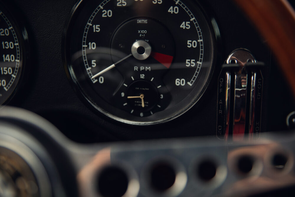 Vintage car dashboard showing RPM gauge and switches