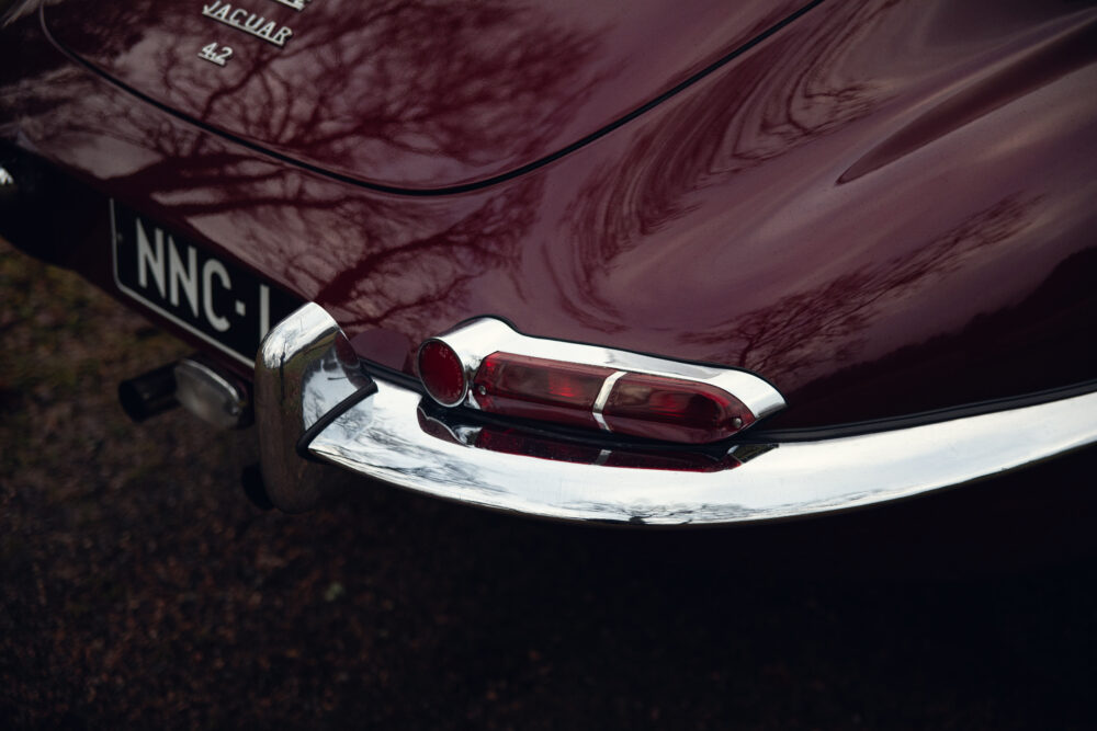 Close-up of vintage Jaguar car's taillight and badge