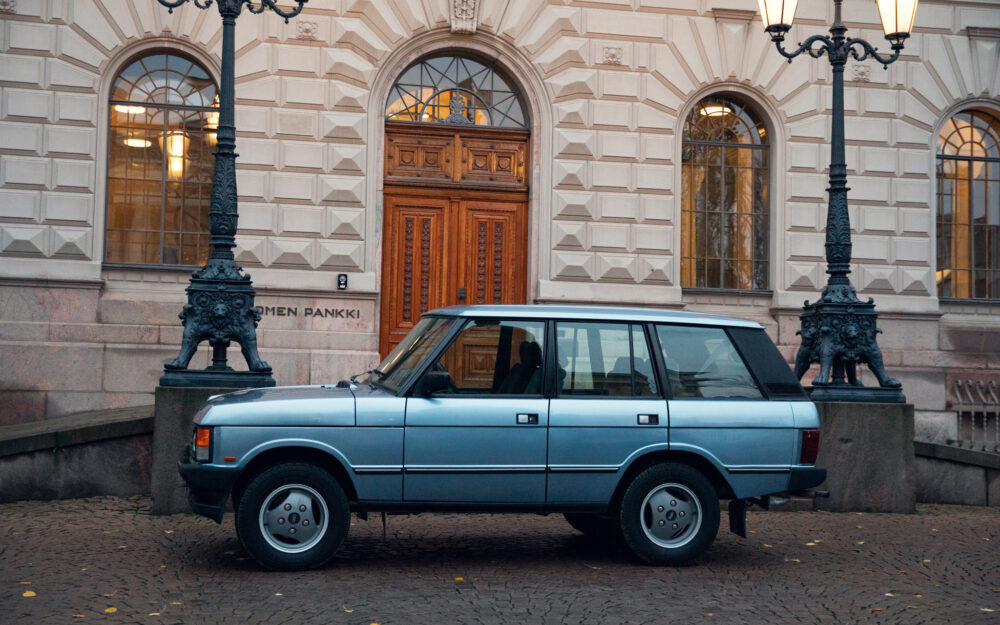 Vintage car parked by ornate lamp post near building