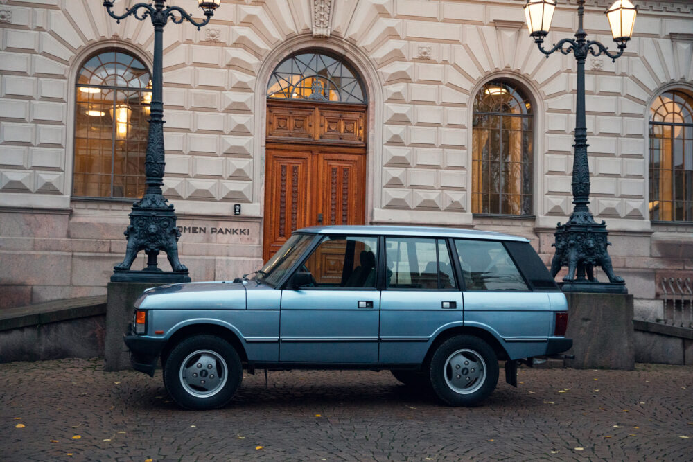Vintage car parked by ornate lamp post near building