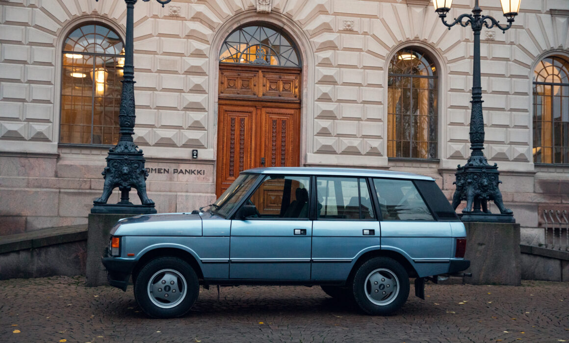 Vintage car parked by ornate lamp post near building