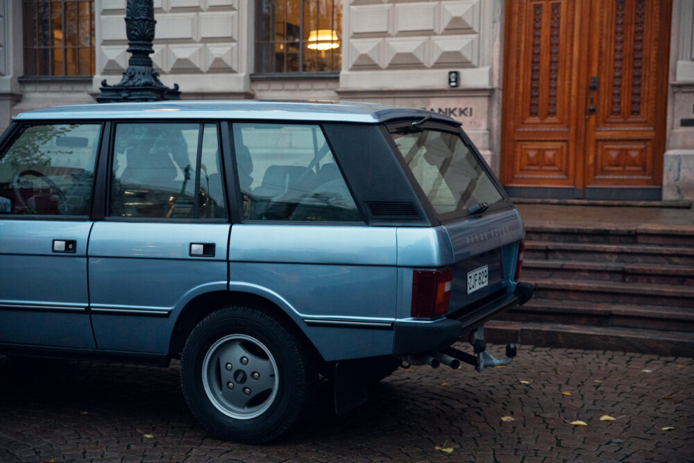 Vintage blue car parked near ornate building entrance