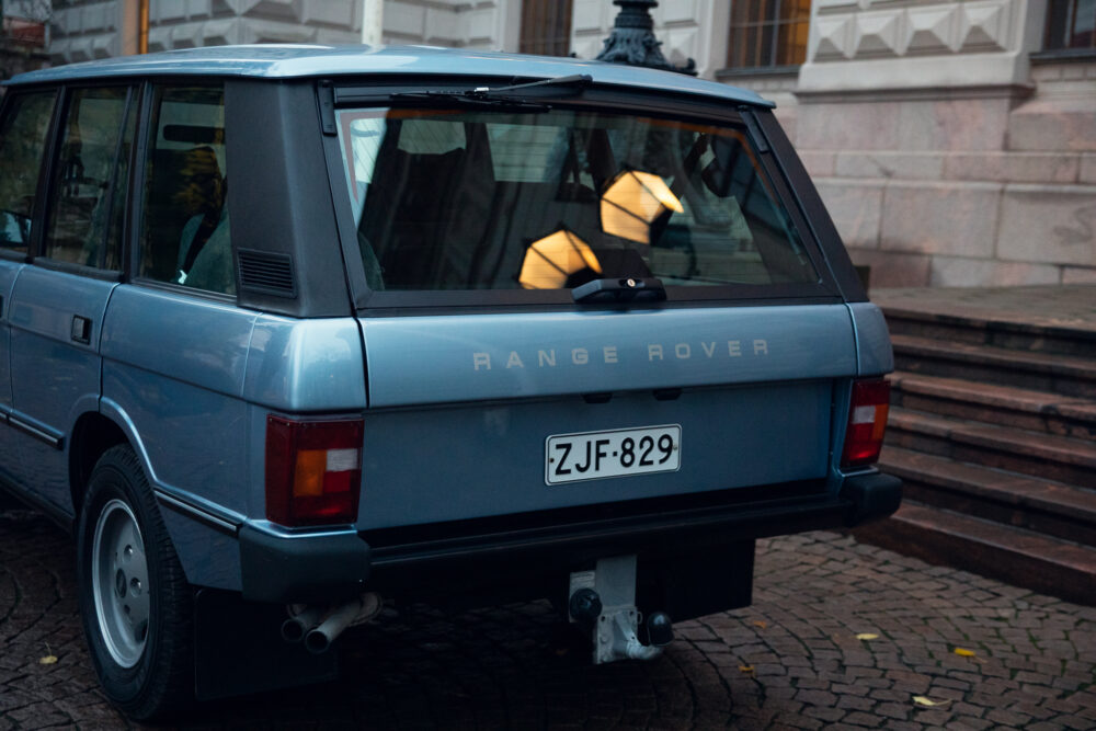Blue Range Rover parked near building at dusk