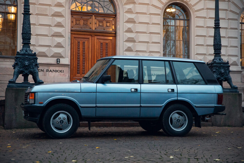 Vintage blue SUV parked near ornate street lamps