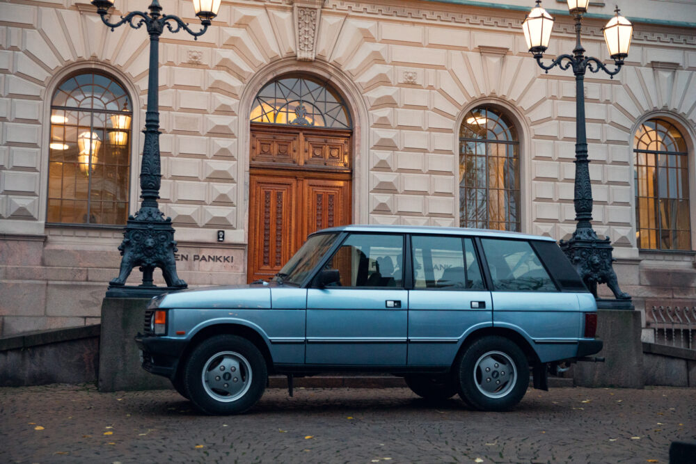 Vintage car parked in front of ornate building entrance