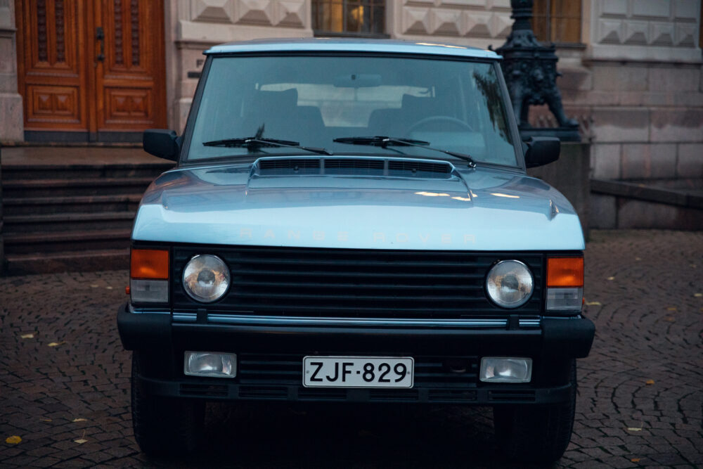 Blue Range Rover parked in front of ornate door