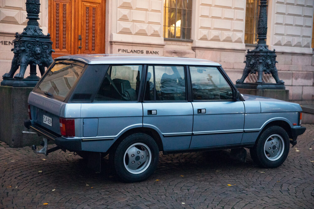 Vintage blue car parked near ornate street lamp