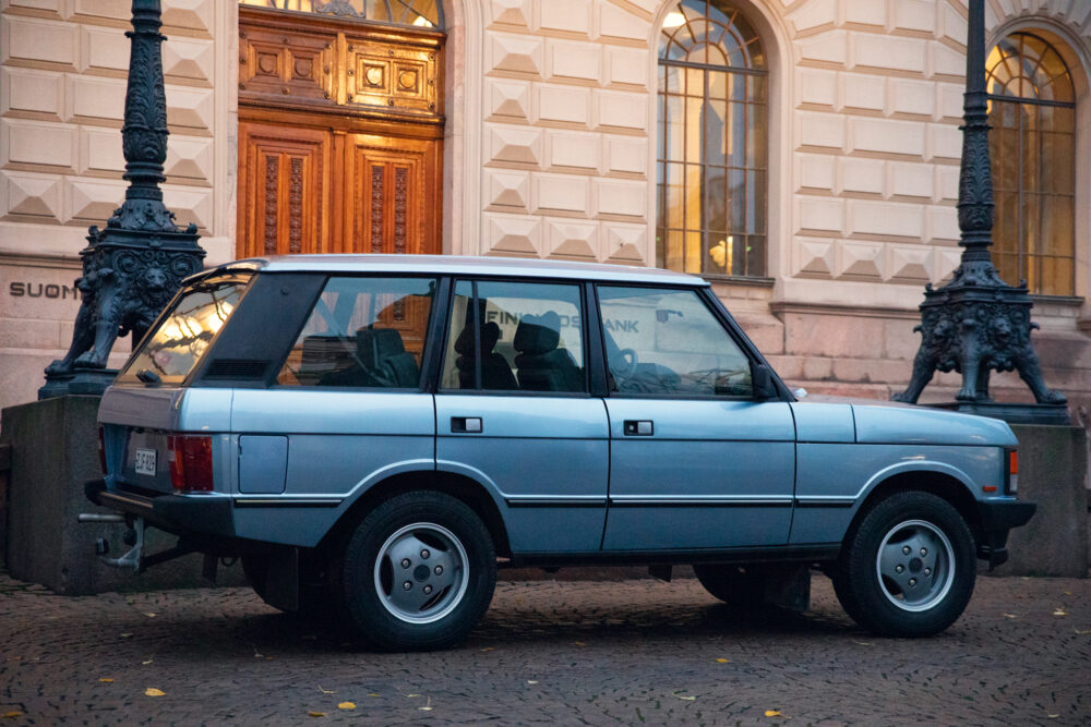 Vintage blue SUV parked near ornate building entrance