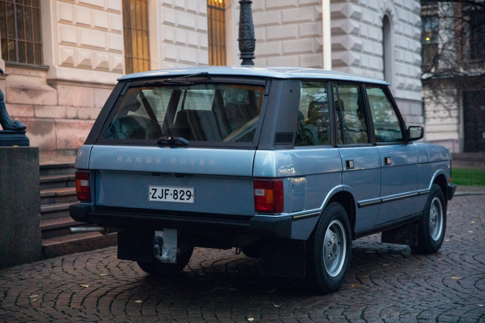 Vintage blue Range Rover parked near historical building
