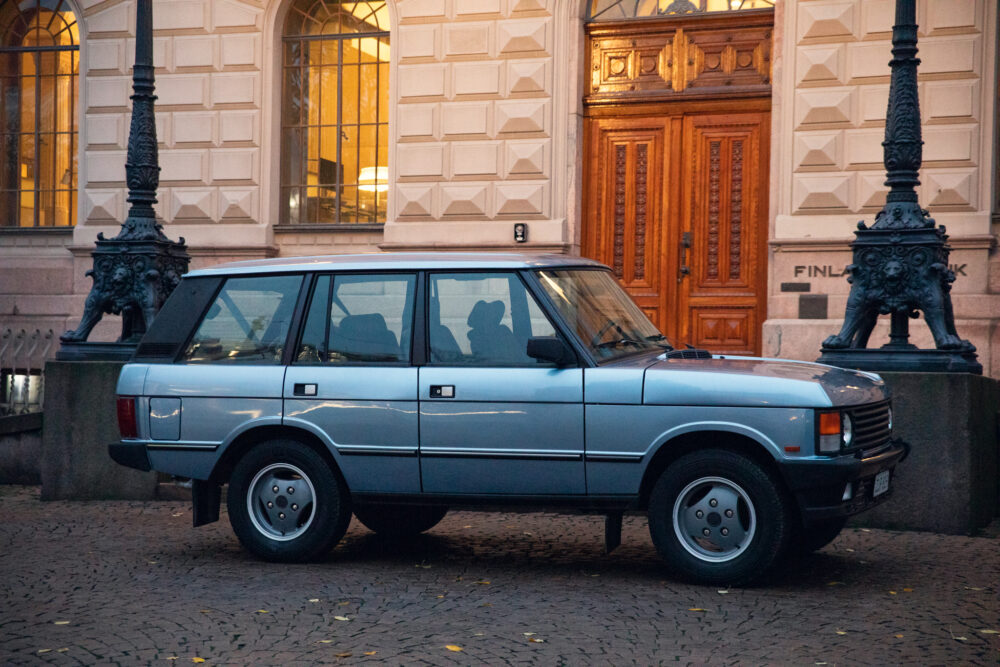 Vintage blue SUV parked near ornate building entrance