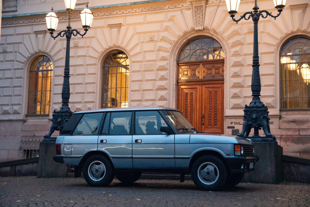 Vintage car parked outside ornate building at dusk