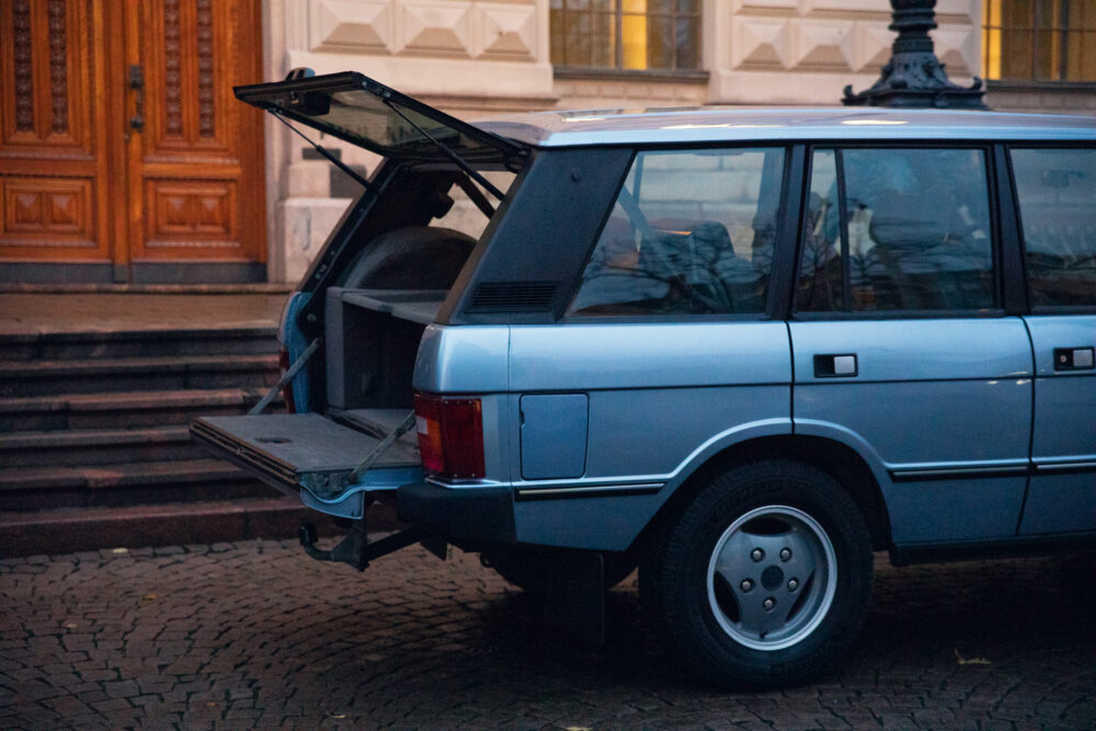 Vintage car with open hatchback near building entrance