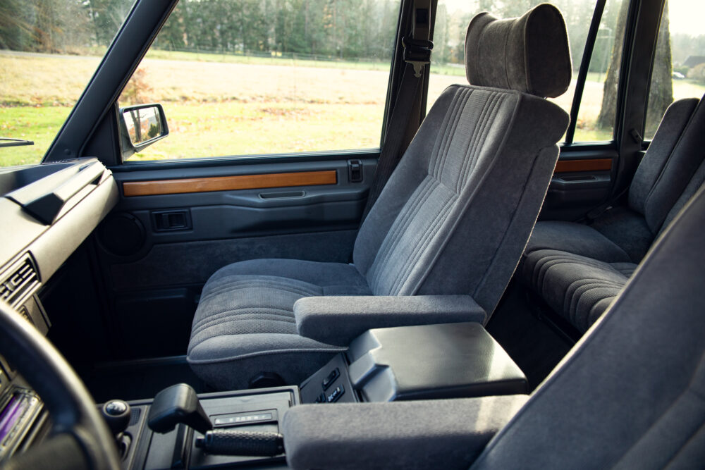 Vintage car interior with grey seats and wooden trim