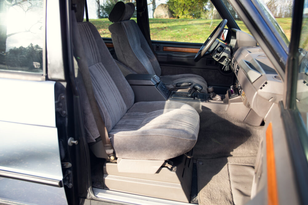 Vintage car interior with open door and fabric seats