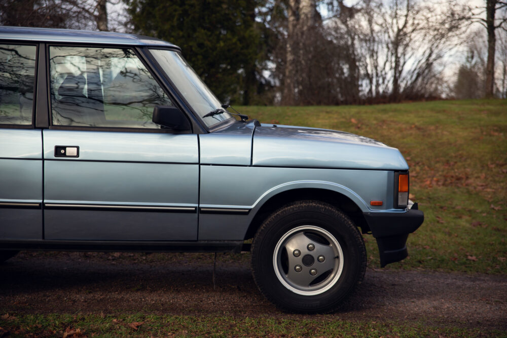 Vintage blue SUV parked outdoors near trees