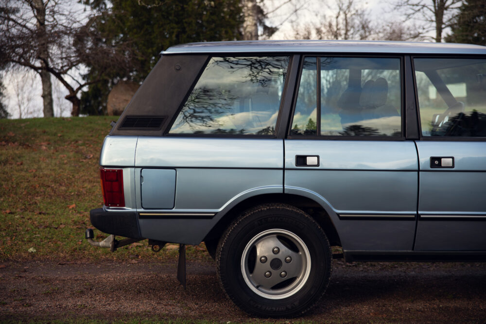 Vintage blue station wagon parked outdoors near trees
