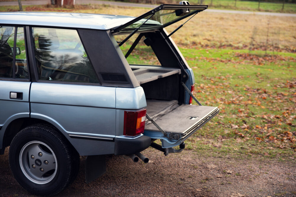 Vintage blue station wagon with open trunk in park