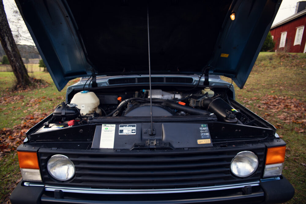 Vintage car engine open in front of barn