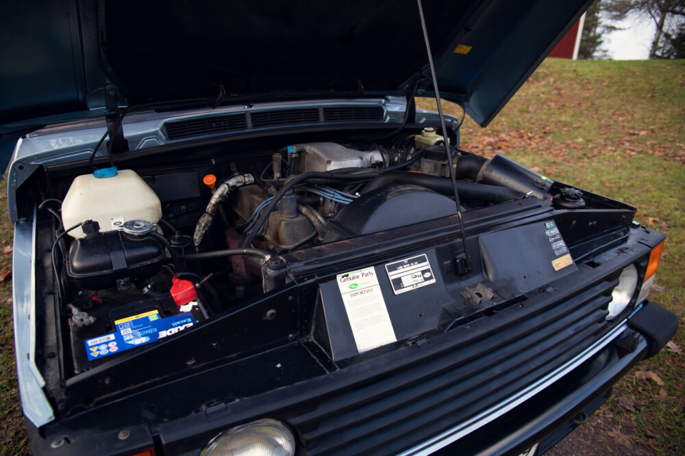 Open hood of vintage car showing detailed engine components