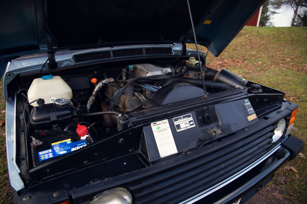 Open hood of vintage car showing detailed engine components