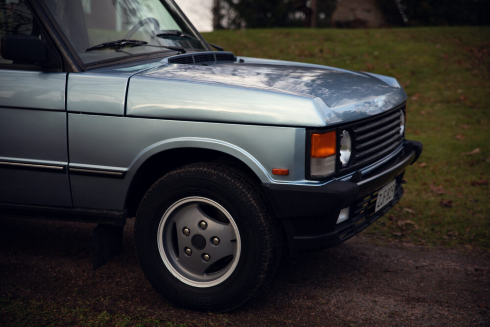 Vintage blue car parked on a grassy area