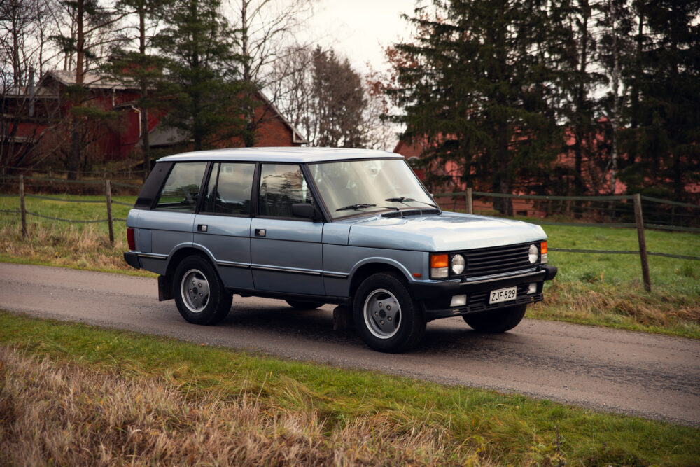 Vintage car on rural road near red barn