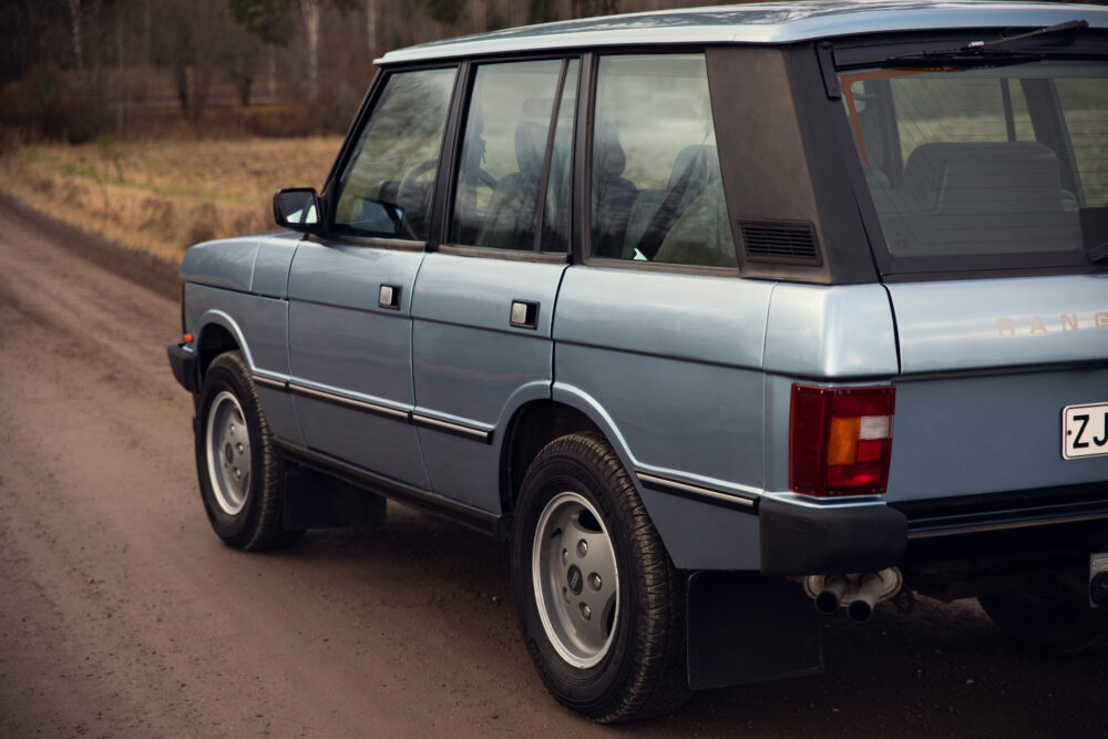 Vintage blue Range Rover on a dirt road