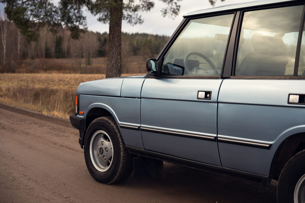 Vintage blue car parked beside country road