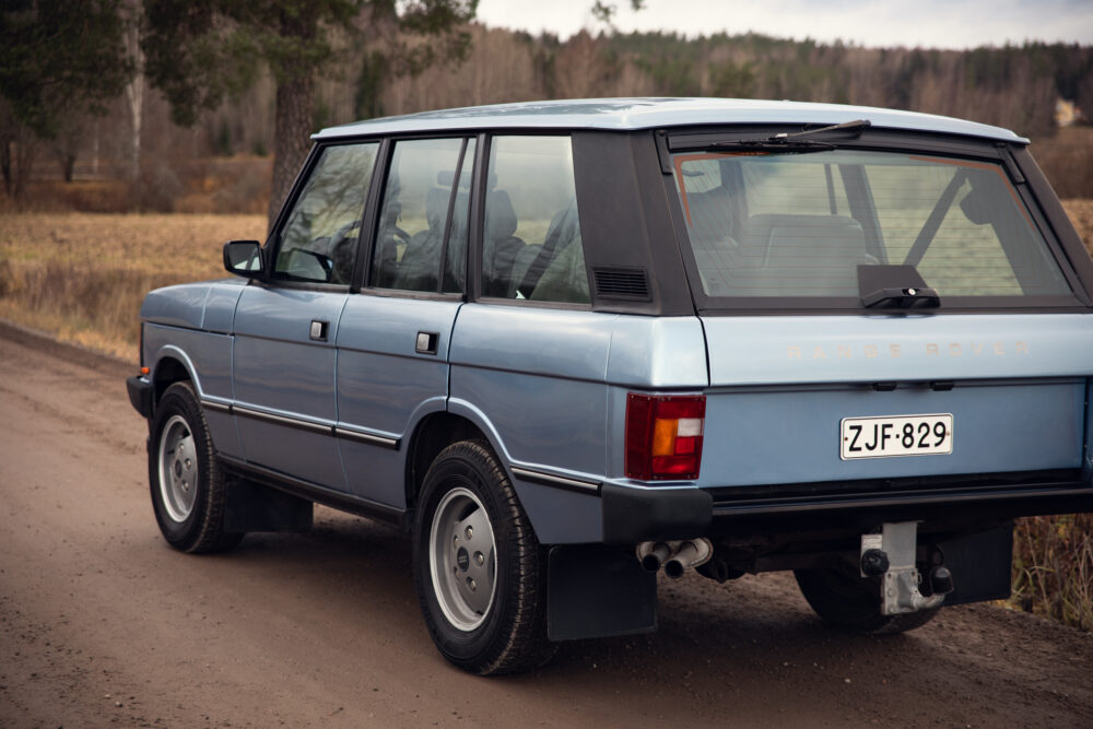 Vintage blue Range Rover parked on dirt road