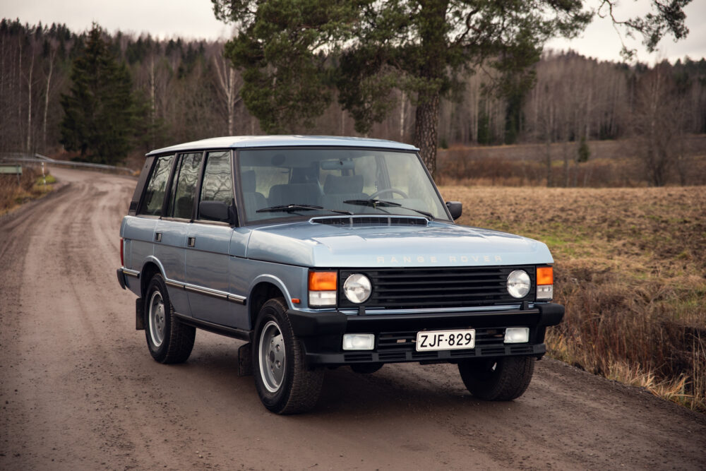 Vintage blue Range Rover on a rural dirt road