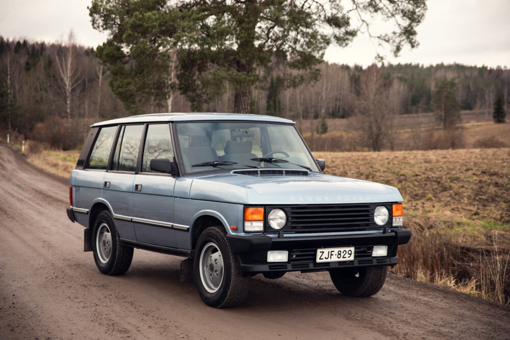 Vintage blue Range Rover on countryside dirt road