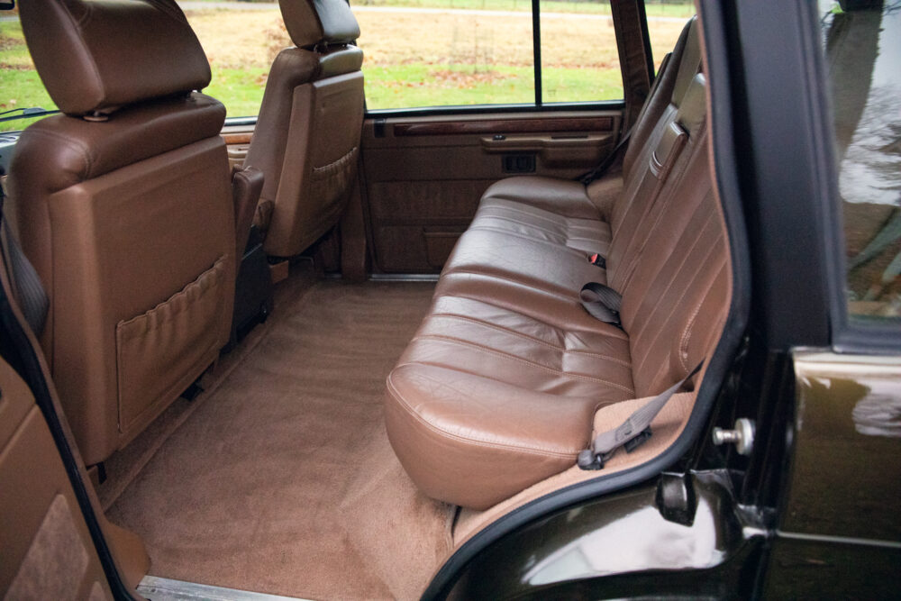 Luxurious brown leather car interior, spacious rear seats