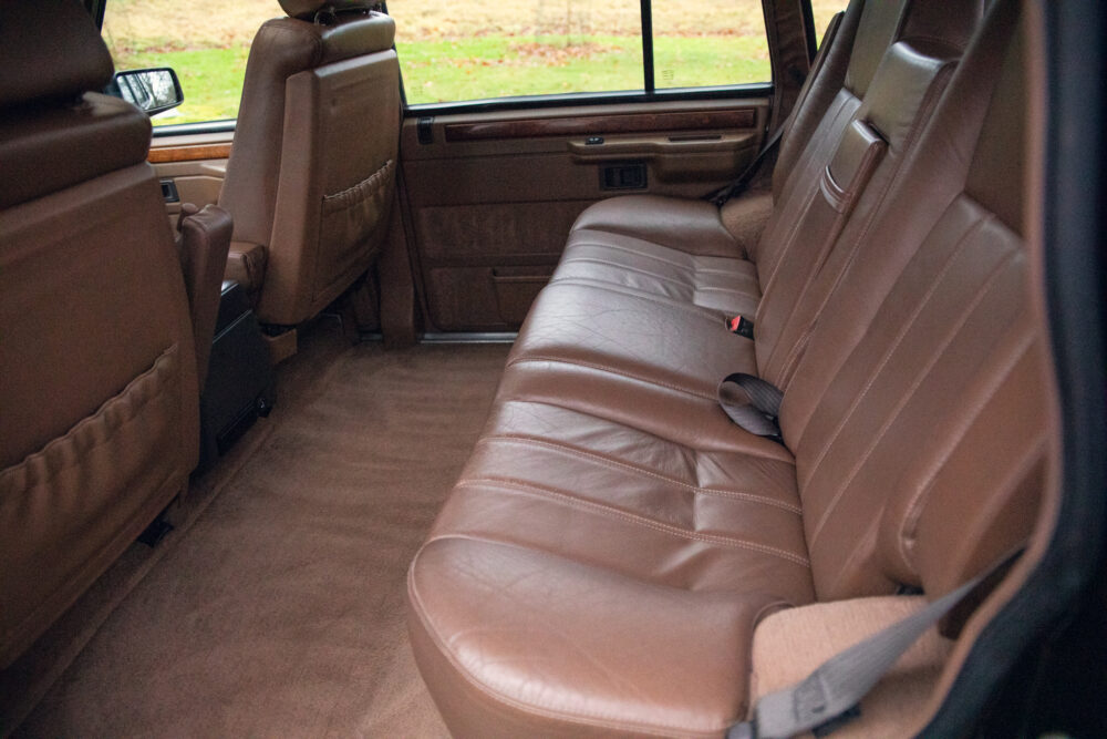 Luxurious brown leather car interior, spacious rear seating