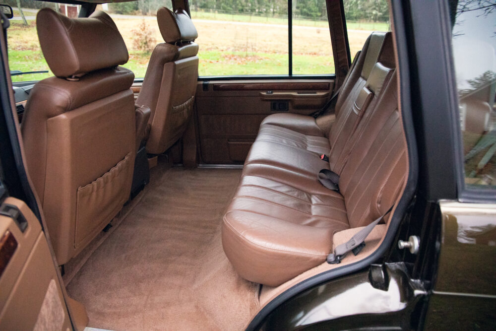 Luxurious brown leather car interior with open door