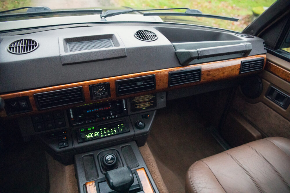 Vintage car interior with wooden dashboard and leather seat