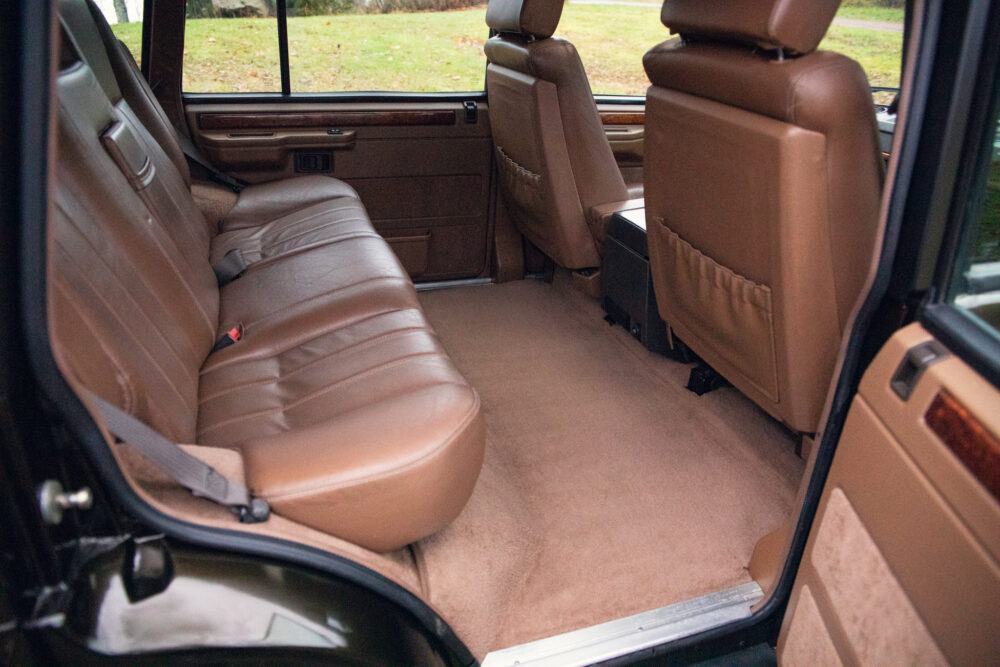 Open rear door showing luxurious leather car interior