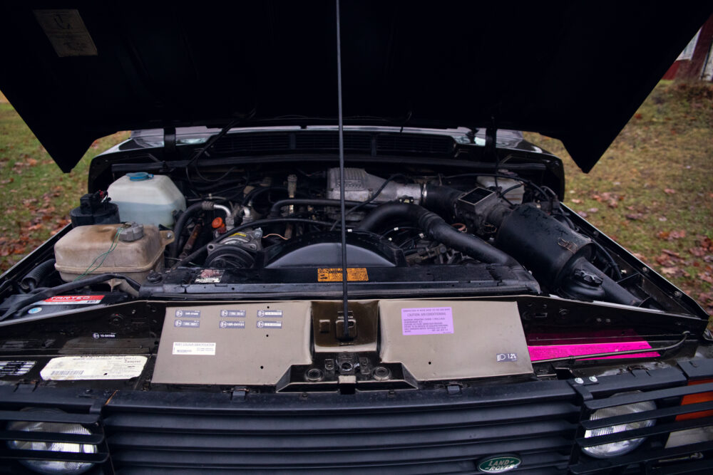 Open hood of vintage car showing detailed engine bay