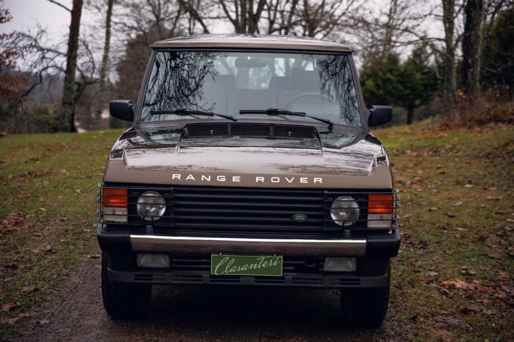 Vintage Range Rover parked on leafy path
