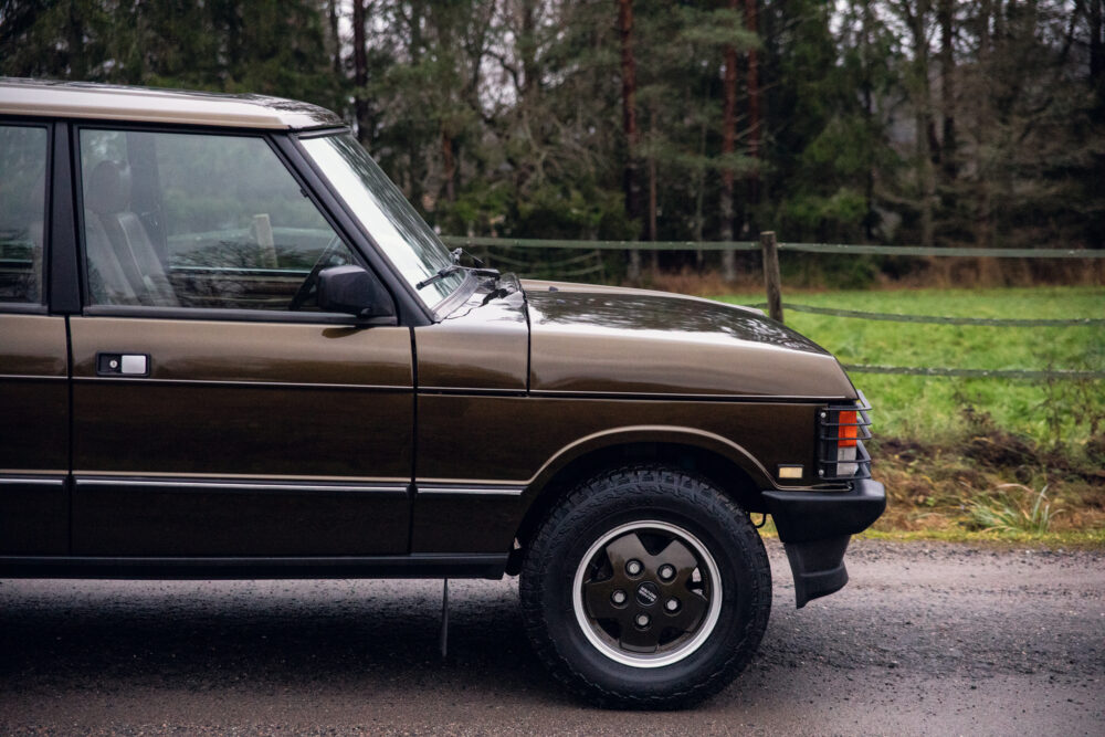 Vintage brown SUV parked on a damp country road
