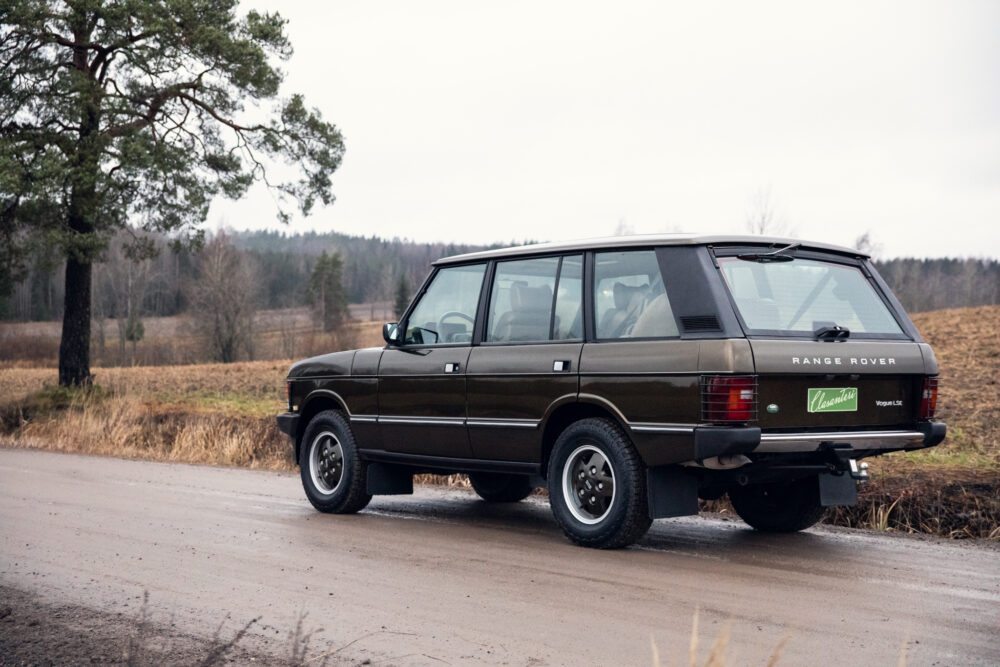 Vintage Range Rover on rural road near trees