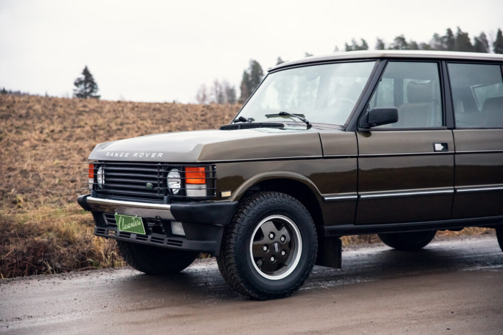 Vintage Range Rover parked on muddy rural road